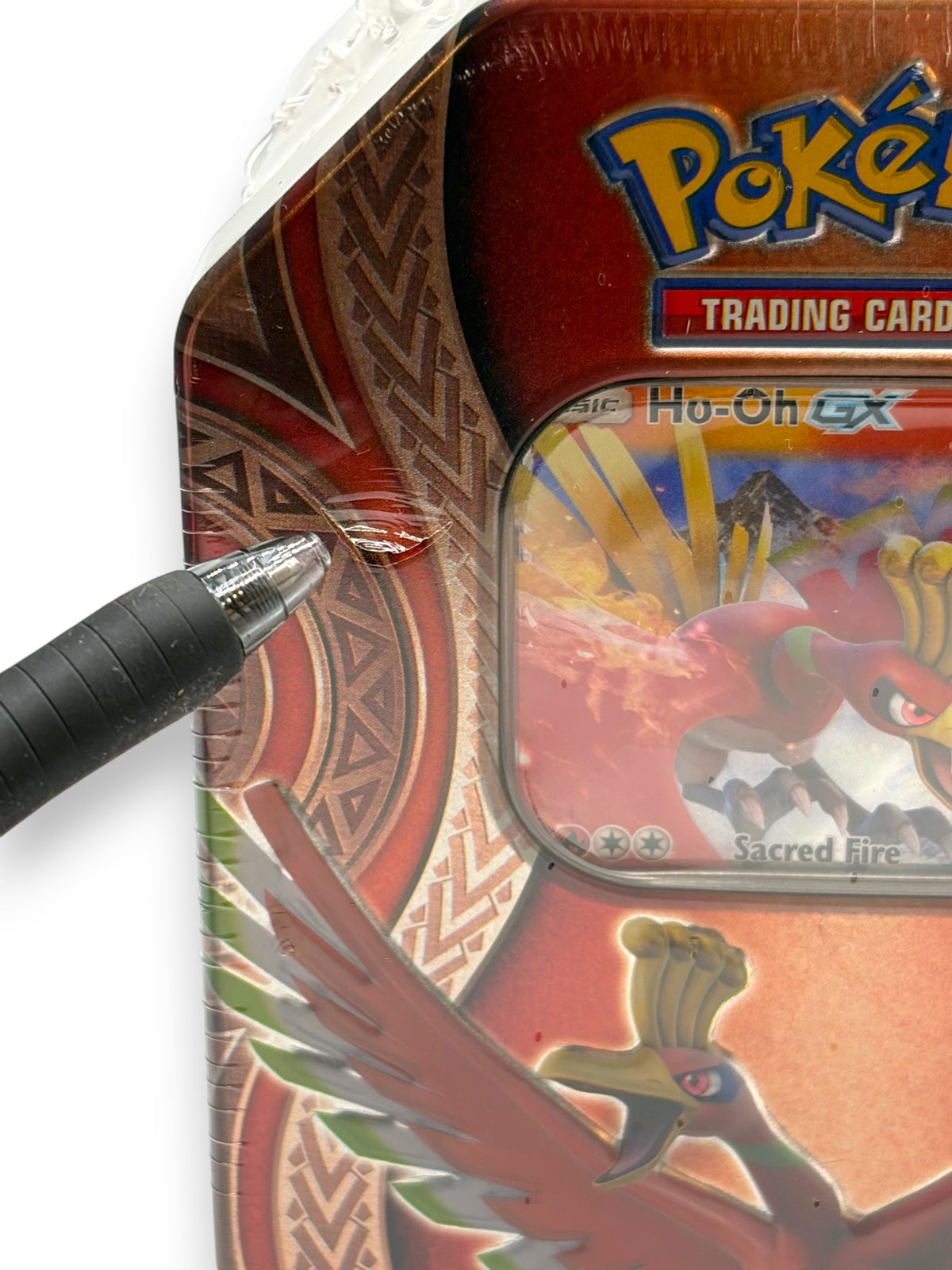 Lowkey Stock sealed Ho-Oh GX Mysterious Powers Pokémon TCG tin showing a small plastic wrap tear pointed at by a pen