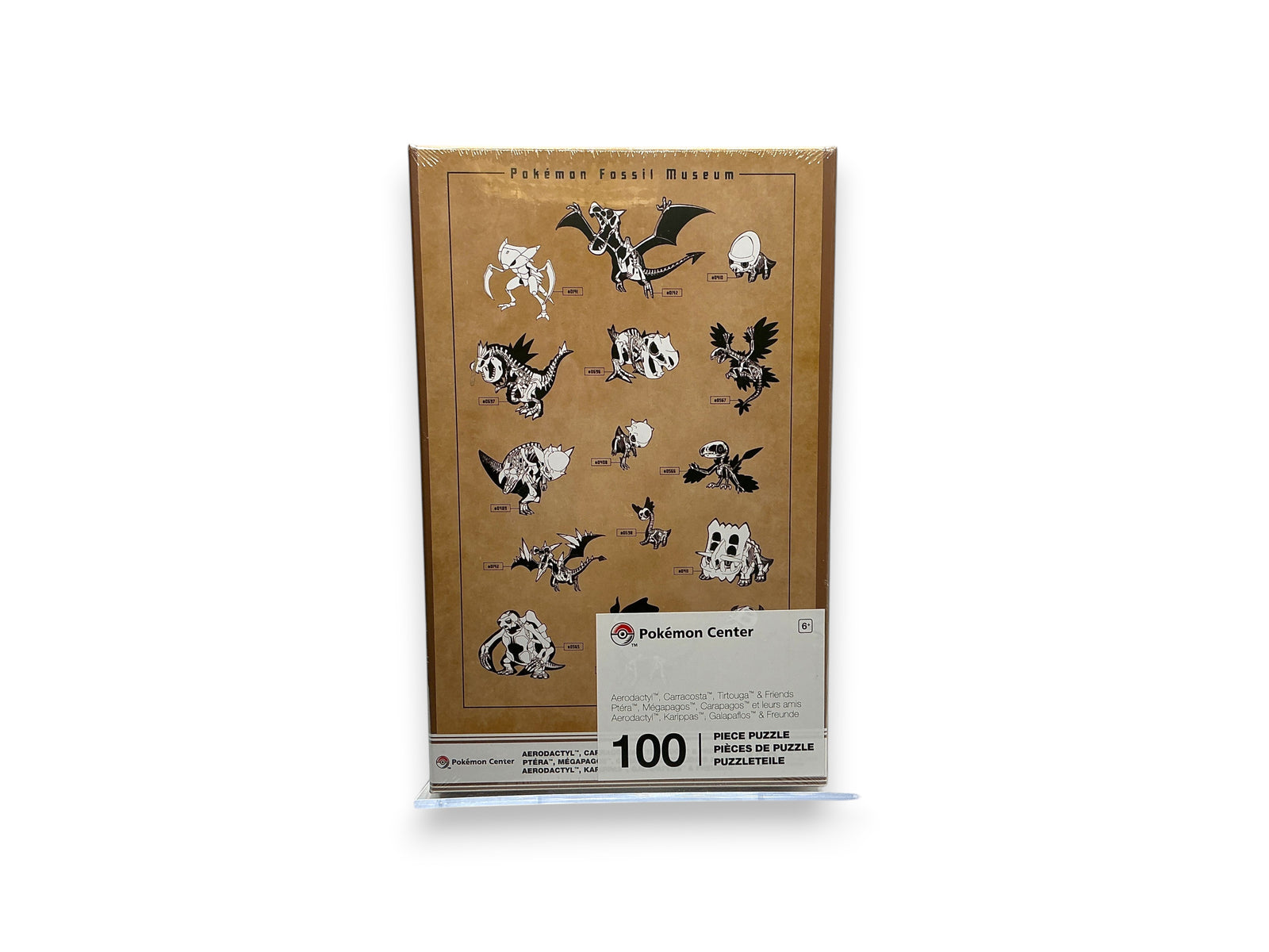 Lowkey Stock Pokémon Center Fossil Museum 100-piece puzzle featuring illustrated skeleton Pokémon on a tan box.