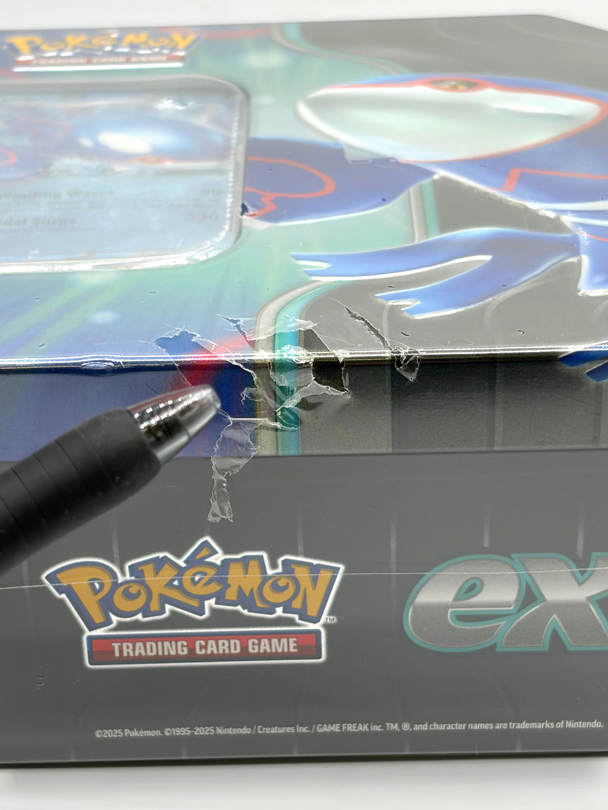 Lowkey Stock Pokémon TCG Azure Legends Kyogre ex tin showing a tear in the plastic seal pointed out by a pen