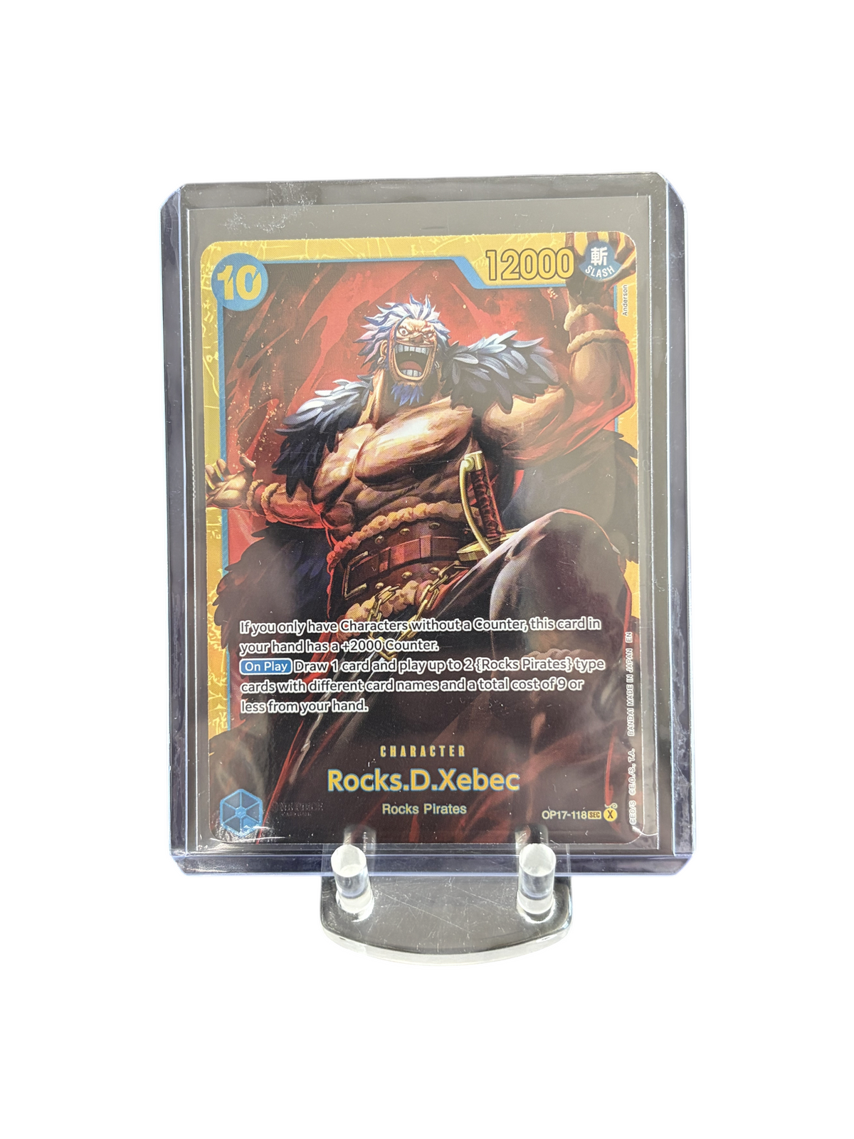 Lowkey Stock Rocks.D.Xebec OP17-118 One Piece trading card in a protective sleeve featuring gold and red artwork.